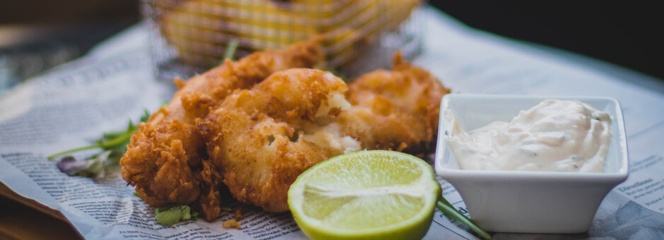 Fresh looking fish and chips with tartar sauce and slice of lime