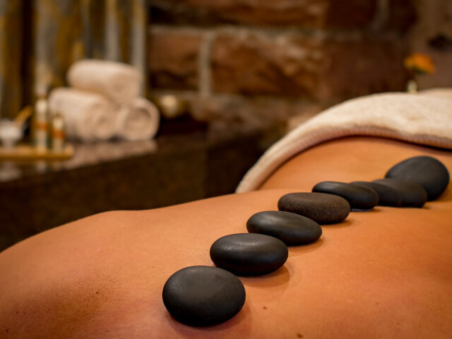 Lady relaxing with a stone treatment in a spa