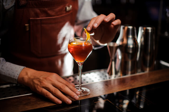 Barman making a cocktail at a bar in Bath