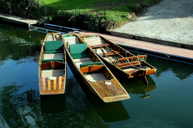 A photo of three punts (boats) by the banks of the River Avon in Bath