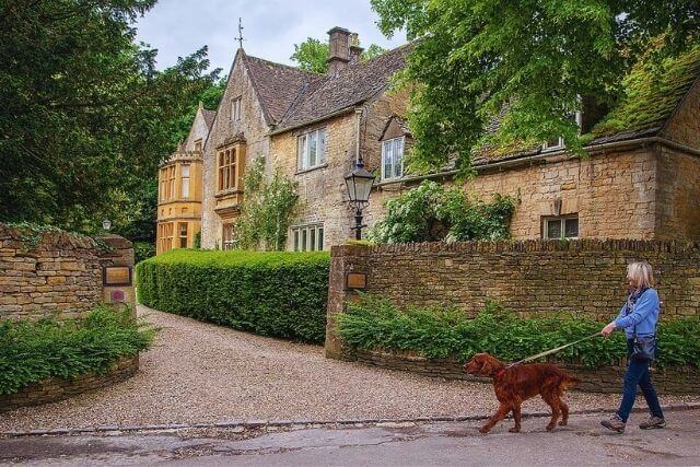 Woman walking dog outside of The Atrium in Upper Slaughter