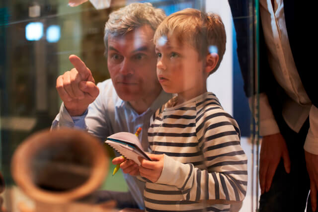 father and son looking at artefacts