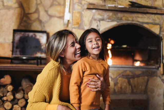 Mother and daughter hugging in front of fireplace at pub near Broadway Cotswolds 