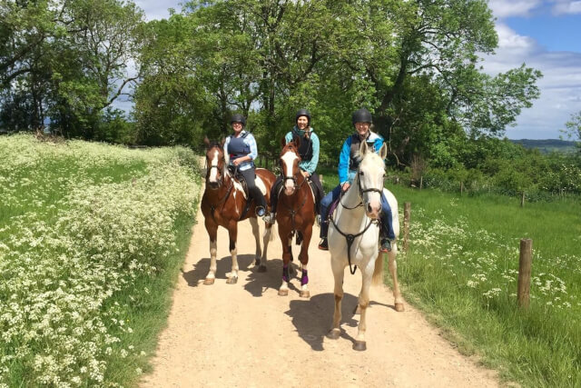 Three women horse-riding in the Cotswolds