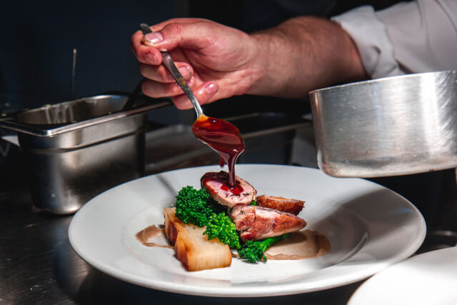 chef pouring gravy on roast dinner